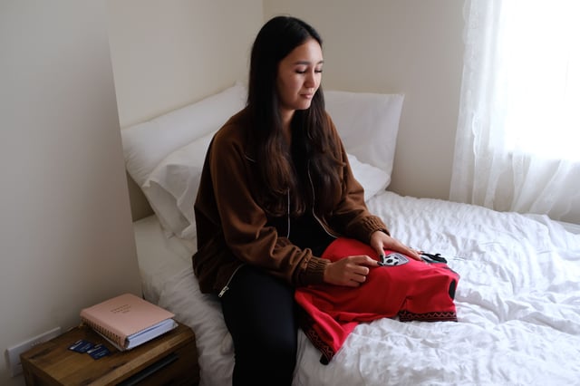 Narges Mayeli sits in her bedroom with an Afghan jersey gifted to her by former coach Khalida Popal.