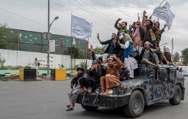 Taliban fighters hold weapons as they ride on humvee to celebrate their victory day near the US embassy in Kabul on August 15, 2022. - Taliban fighters chanted victory slogans next to the US embassy in Kabul on August 15 as they marked the first anniversary of their return to power in Afghanistan following a turbulent year that saw women's rights crushed and a humanitarian crisis worsen. (Photo by Wakil KOHSAR / AFP) (Photo by WAKIL KOHSAR/AFP via Getty Images)
