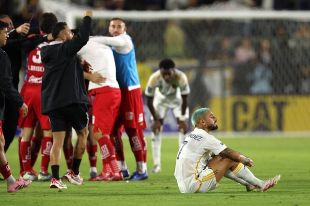 Galaxy midfielder Diego Fagundez sits on the field as Toluca FC players celebrate their 3-2 victory in the Campeones Cup match on Wednesday, Oct. 1, 2025, at Dignity Health Sports Park in Carson. (Photo by Raul Romero Jr., Contributing Photographer)