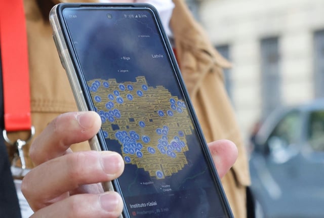 Un bénévole de la protection civile en Lituanie montre une carte du pays affichant les abris prévus en cas de "situations extrêmes", à Vilnius le 21 août 2025