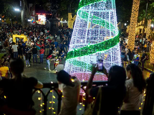 AME4332. CARACAS (VENEZUELA), 01/10/2025.- Personas participan en las fiestas por el inicio de la temporada navideña este miércoles, en Caracas (Venezuela). Las autoridades de Venezuela encendieron oficialmente unas anticipadas Navidades y aseguraron que estas se celebrarán "en paz", en medio de la tensión con Estados Unidos por el despliegue militar que este país mantiene en el mar Caribe para, según Washington, combatir el supuesto narcotráfico procedente de la nación suramericana. EFE/Miguel Gutiérrez