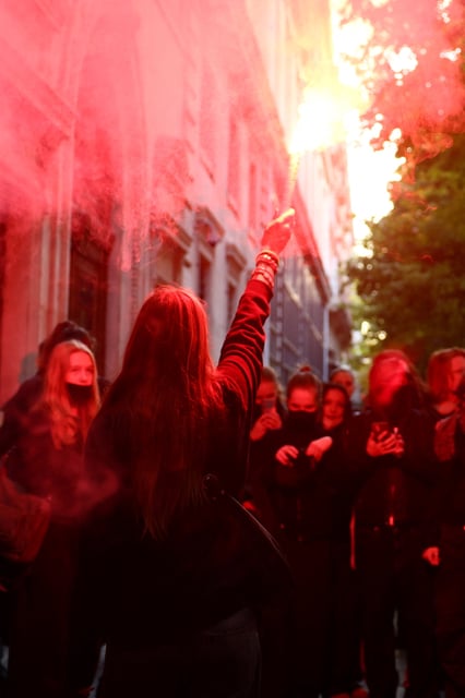 A student holds a red flare as French school students block the entrance of the Lycee Turgot High School in Paris as part of a day of nationwide strikes and protests against the government and possible austerity cuts, France, October 2, 2025. REUTERS/Sarah Meyssonnier