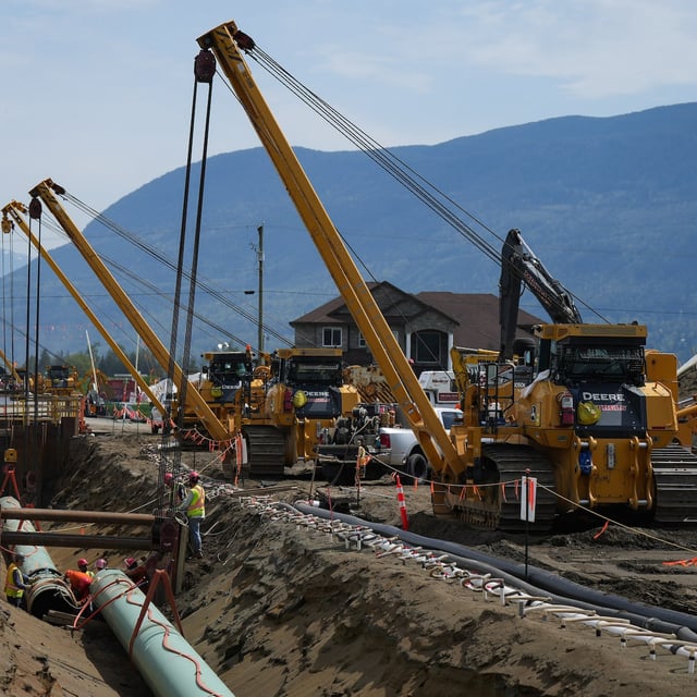 Workers lay pipe during the construction of the Trans Mountain pipeline expansion, in Abbotsford, B.C., in 2023.