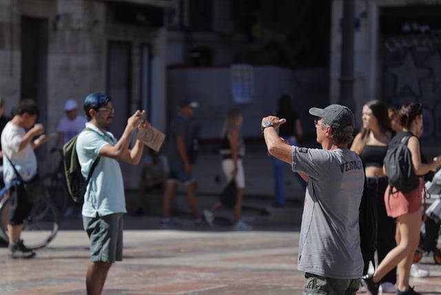 Turistas extranjeros hacen fotos en el centro de València, este verano.