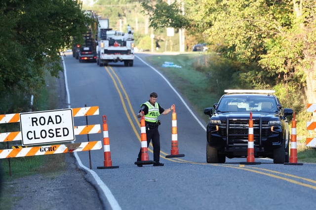 A police officer replaces the cones to block a road near the Church of Jesus Christ of Latter-day Saints, in Grand Blanc Township, Mich., on Sept. 29, 2025.