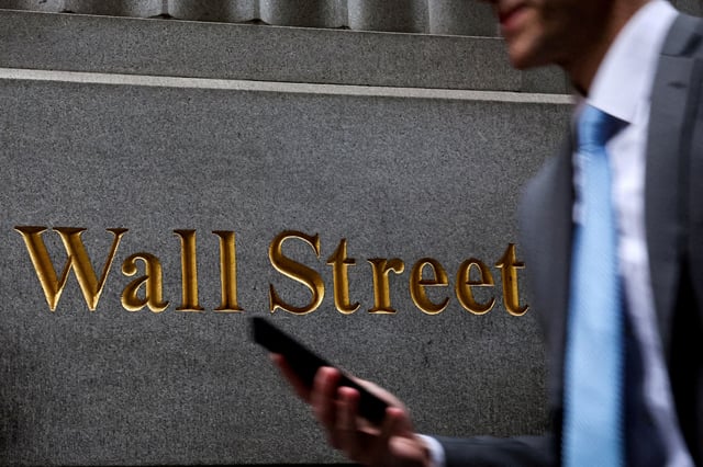 A man walks on Wall Street outside the New York Stock Exchange (NYSE) in New York City, U.S., April 7, 2025. REUTERS/Brendan McDermid/File Photo