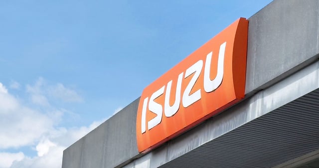 Isuzu dealership signage on building exterior under clear sky.