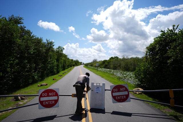 National Park Service law enforcement ranger Greg Freeman opens a locked gate closing vehicle access to the Shark Valley section of Florida’s Everglades National Park, as he drives into the park, Wednesday, Oct. 1, 2025. (AP Photo/Rebecca Blackwell)