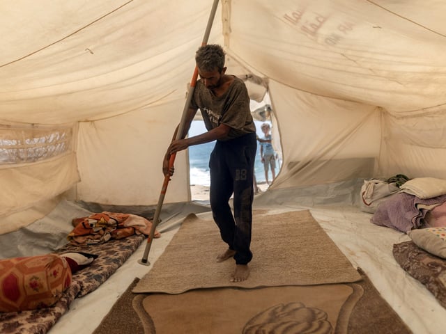 Bassem al-Qedra, de 43 años y padre de seis hijos, monta una tienda de campaña tras conseguir un lugar en el campamento de al-Mawasi, cerca de Khan Younis, en la Franja de Gaza, el miércoles 17 de septiembre de 2025. En medio del ataque terrestre del ejército israelí contra la ciudad de Gaza, la enorme afluencia de gazatíes que huyen hacia el sur ha sobrecargado aún más los servicios humanitarios, que, según los grupos de ayuda, eran insuficientes incluso antes de la llegada de muchos miles más. (Saher Alghorra/The New York Times)