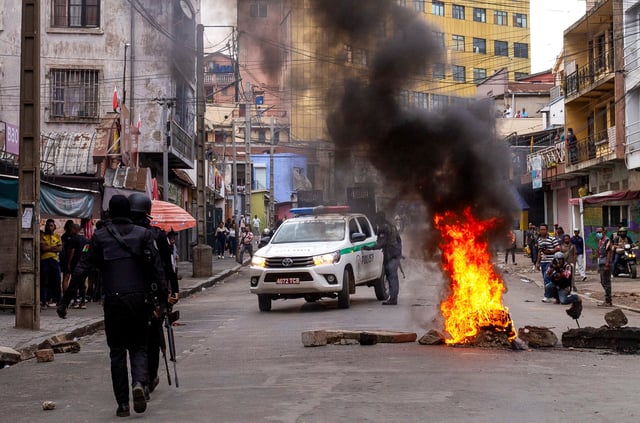 Police officers walk near a barricade on a road, during a demonstration against frequent power outages and water shortages, in the capital Antananarivo, Madagascar, October 1, 2025. REUTERS/Zo Andrianjafy