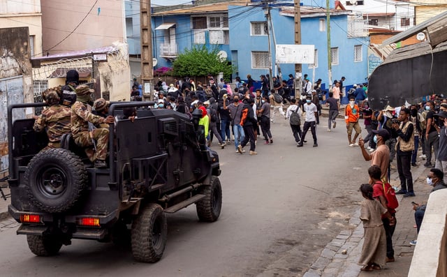 Protesters watch as riot police officers drive past during a demonstration against frequent power outages and water shortages, in the capital Antananarivo, Madagascar, October 1, 2025. REUTERS/Zo Andrianjafy