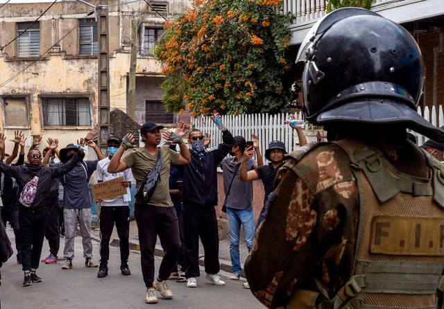 Protesters gesture in front of riot police officers during a demonstration against frequent power outages and water shortages, in the capital Antananarivo, Madagascar, October 1, 2025. REUTERS/Zo Andrianjafy