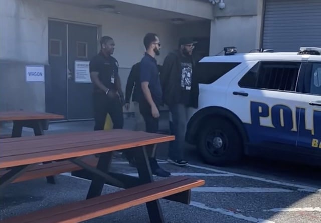 Baltimore Police arrested Kevin Weaver  41, of Halethorpe, far right, on Wednesday after he turned himself in. The bouncer is charged with first-degree assault after a video of him putting a young man in a chokehold outside a Fells Point restaurant on Saturday went viral. (Baltimore Police Department photo)