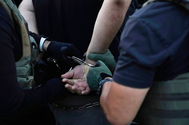 U.S. Immigration and Customs Enforcement agents make an arrest during an early morning operation in Park Ridge, Ill., Sept. 19, 2025.