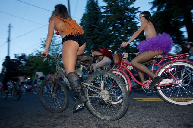 Cyclists pour into the streets of Portland for the 11th annual World Naked Bike Ride June 7, 2014. Thousands of bicyclists, many of them stark naked, poured into the streets of Portland, Oregon on Saturday night for the event, a protest that promotes bike riding as an alternative to driving cars.