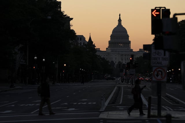 The sky begins to brighten just before sunrise behind the U.S. Capitol on the second day of a federal government shutdown in Washington, D.C. on Oct. 2, 2025.
