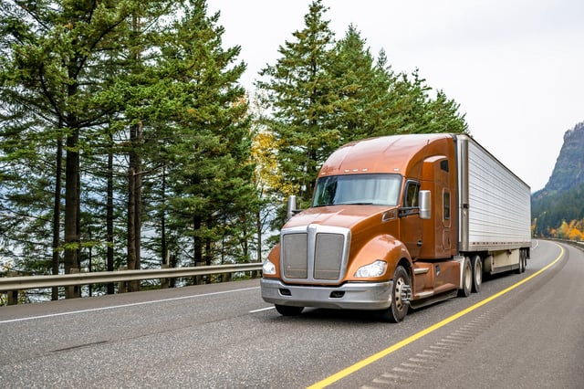 A stock photo shows a large truck driving on a highway.