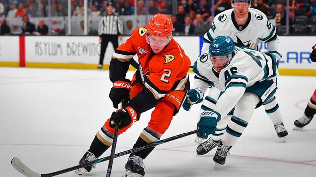 Apr 1, 2025; Anaheim, California, USA; Anaheim Ducks defenseman Jackson LaCombe (2) moves the puck against San Jose Sharks center Cam Lund (46) during the second period at Honda Center. Mandatory Credit: Gary A. Vasquez-Imagn Images