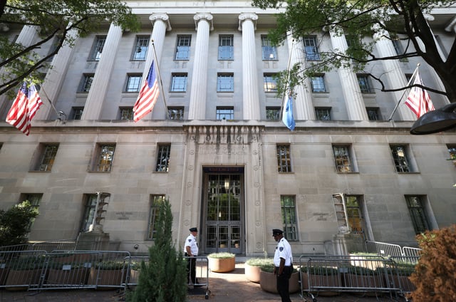 Officers keep watch outside the Department of Justice building in Washington, D.C., U.S., September 23, 2025. REUTERS/Kevin Lamarque