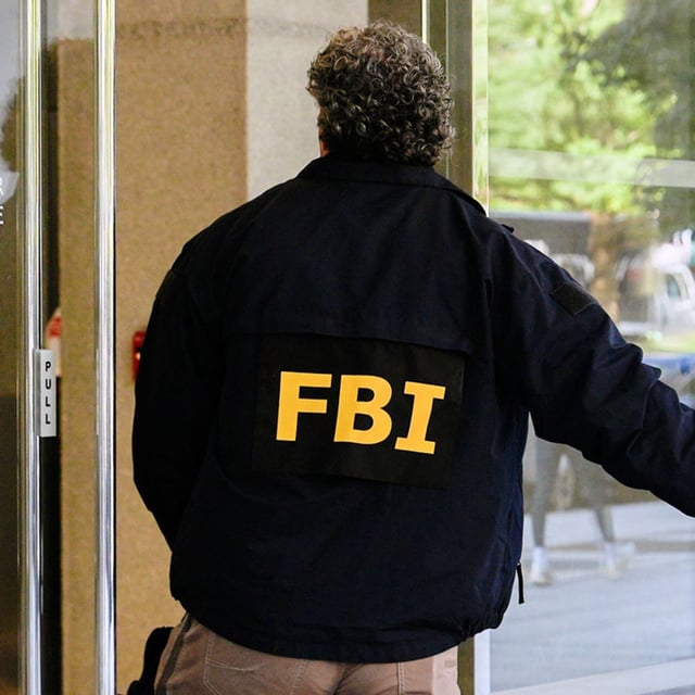 FILE - An FBI agent walks inside the front entrance of ex-Trump national security adviser John Bolton's Washington office, Aug 22, 2025. (AP Photo/Julia Demaree Nikhinson, File)