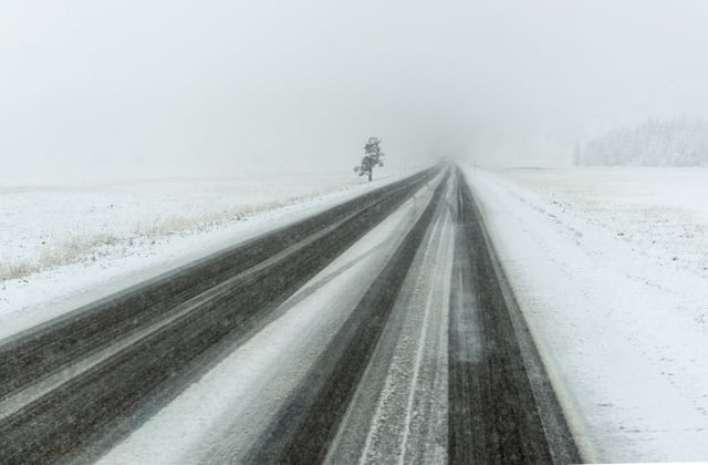 A stock image of a snowy road in Wyoming.