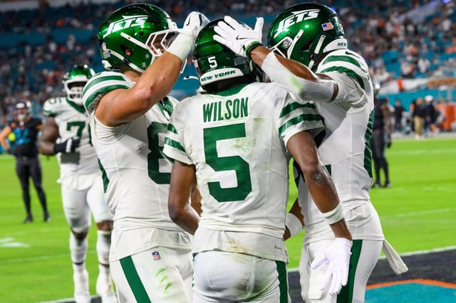 New York Jets wide receiver Garrett Wilson (5) celebrates scoring a touchdown with tight end Mason Taylor (85) and wide receiver Arian Smith (82) during an NFL football game against the Miami Dolphins, Monday, Sept. 29, 2025, in Miami Gardens, Fla. (AP Photo/Doug Murray)