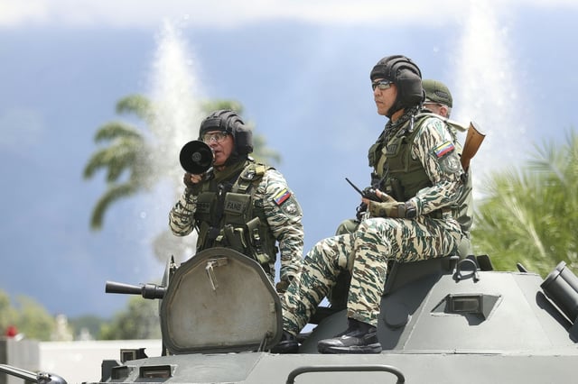 Le ministre vénézuélien de la Défense, Vladimir Padrino Lopez, s'exprime à l'aide d'un mégaphone depuis un char de l'armée vénézuélienne après un exercice militaire, sur une autoroute à Caracas, le 20 septembre 2025