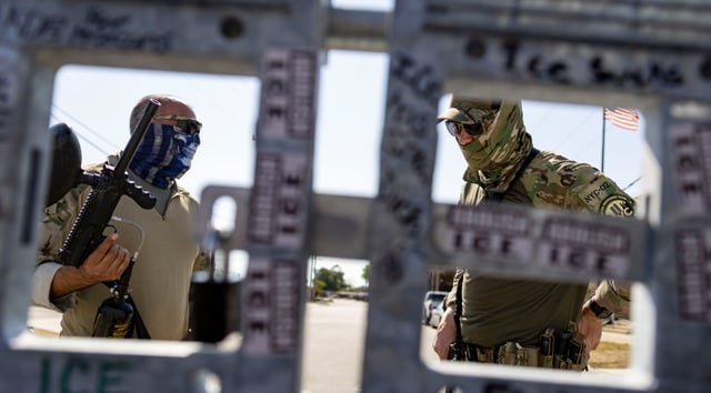 Federal agents stand inside the fence at the U.S. Immigration and Customs Enforcement holding facility in Broadview on Sept. 28, 2025. (Brian Cassella/Chicago Tribune)