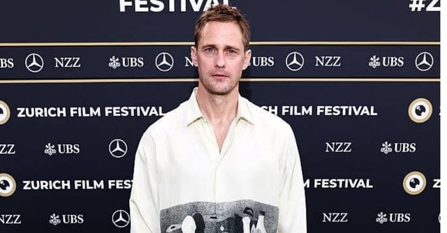 Man smiling at event in a collared shirt; elegant and casual appearance