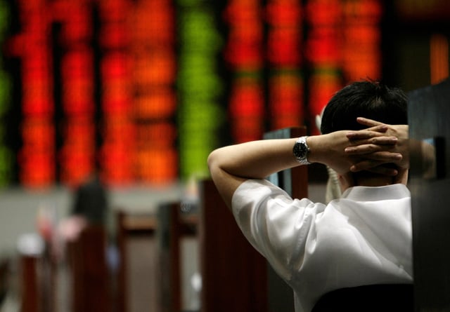 A trader looks at the electronic board on the floor of the Philippine Stock Exchange at the end of the trading day in Makati City, metro Manila November 12, 2007. REUTERS/Darren Whiteside
