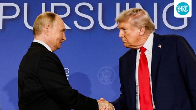 Donald Trump and Vladimir Putin shake hands during a press conference