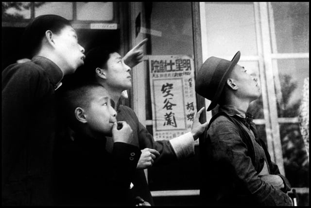 Ciudadanos chinos mirando una batalla aérea entre un bombardero japonés y cazas de su país en día del cumpleaños del Emperador Hirohito's en Hankou, provincia de Hubei, China (1938).