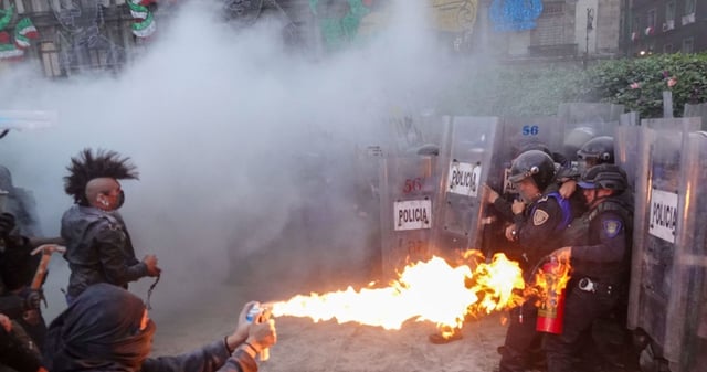 Integrantes del llamado Bloque Negro se enfrentaron a Policías Capitalinos en el Zócalo, durante el mitin conmemorativo de la Matanza Estudiantil de 1968 en Tlatelolco. Los jóvenes encapuchados agredieron a los uniformados con cuetones, bombas molotov, piedras y palos. Los integrantes de la SSC solo los contuvieron hasta que llegaron más refuerzos y pudieron replegarlos, el saldo es de varios heridos. Foto: Galo Cañas Rodríguez, Curtoscuro