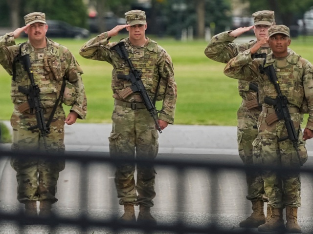 National Guard soldiers salute as President Donald Trump's motorcade drives by, Saturday, Sept. 20, 2025, in Washington. (AP Photo/Julia Demaree Nikhinson)