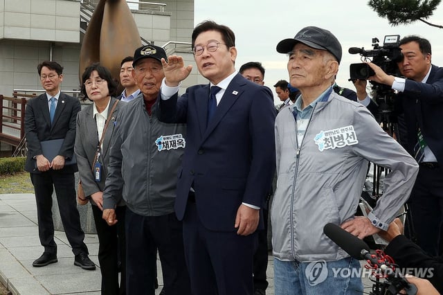 President Lee Jae Myung (C) talks with people who were displaced during the 1950-53 Korean War while looking toward North Korea at the Ganghwa Peace Observatory in the western city of Incheon on Oct. 3, 2025. (Pool photo) (Yonhap)