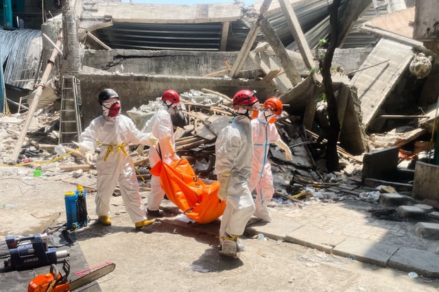 Rescuers carry the body of a victim of a collapsed building at an Islamic boarding school in Sidoarjo, East Java, Indonesia, Friday, Oct. 3, 2025. (AP Photo/Trisnadi)