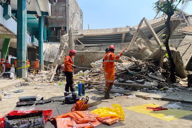 Rescuers spray disinfectant during the search for victims of a collapsed building at an Islamic boarding school in Sidoarjo, East Java, Indonesia, Friday, Oct. 3, 2025. (AP Photo/Trisnadi)