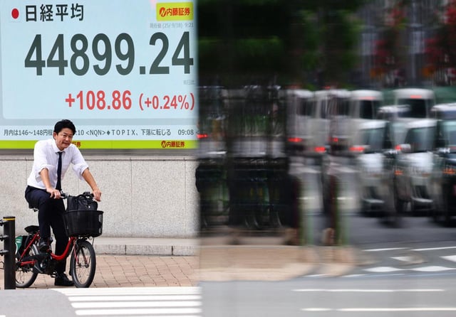 Un homme passe devant un tableau de cotation affichant la moyenne des actions Nikkei devant un courtier à Tokyo, le 18 septembre 2025.