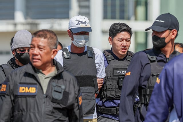 Ekkalak Paenoi, a suspect in the assassination of a former politician with now-dissolved Cambodia National Rescue Party (CNRP) Lim Kimya, 74, is escorted by police officers as he arrives in Thailand following handing over from Cambodia to Thai authorities, in Bangkok, Thailand, January 11, 2025. REUTERS/Chalinee Thirasupa