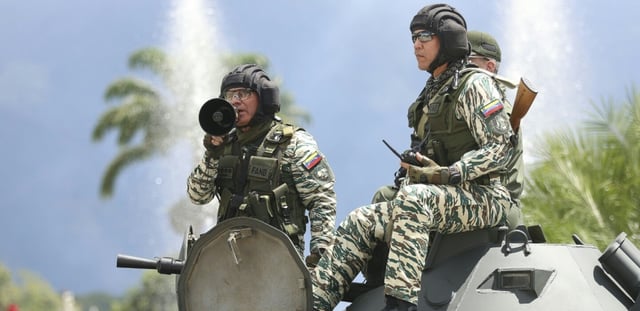 Le ministre vénézuélien de la Défense, Vladimir Padrino Lopez, s'exprime à l'aide d'un mégaphone depuis un char de l'armée vénézuélienne après un exercice militaire, sur une autoroute à Caracas, le 20 septembre 2025