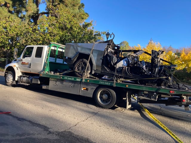 A two truck removes the charred remains of a Tesla Cybertruck that crashed early Wednesday, killing three people and injuring another one. The California Highway Patrol is investigating (Harry Harris/Bay Area News Group).