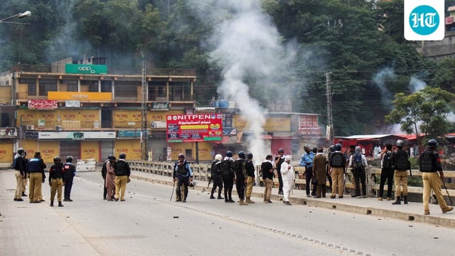 Police officers stand on a bridge, as they stop the protesters of the Awami Action Committee, during a protest following a shutter-down strike in Muzaffarabad, the capital of Pakistan-occupied Kashmir. 