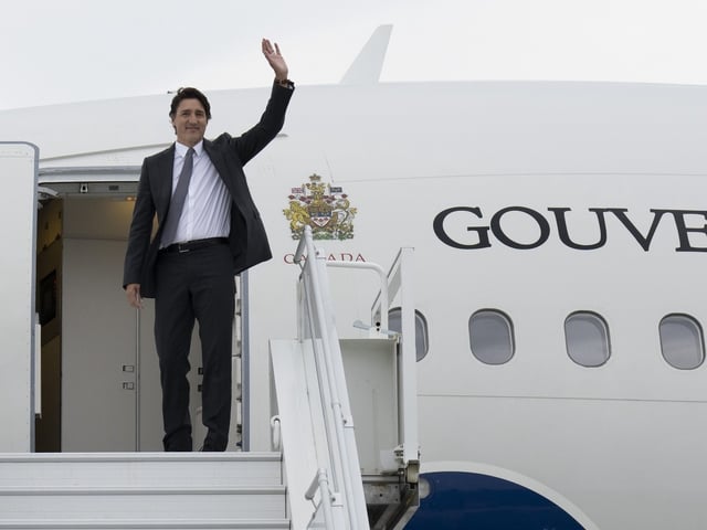 Then-PM Justin Trudeau waves as he boards a government plane in Ottawa is this photo from July 2023.