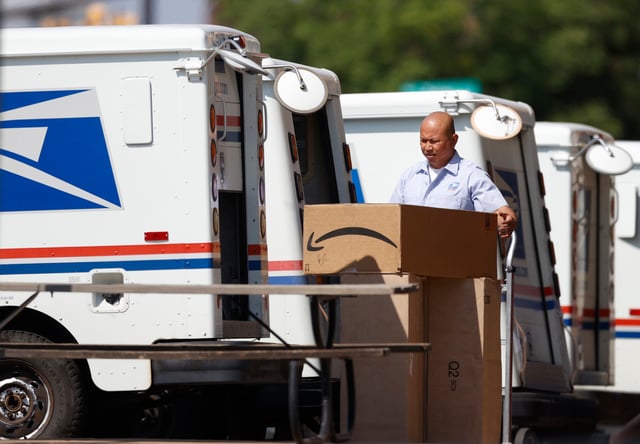 A carrier loads a van to make daily deliveries from the United States Postal Service office Monday, Aug. 17, 2020, in Greenwood Village, Colo. (AP Photo/David Zalubowski)