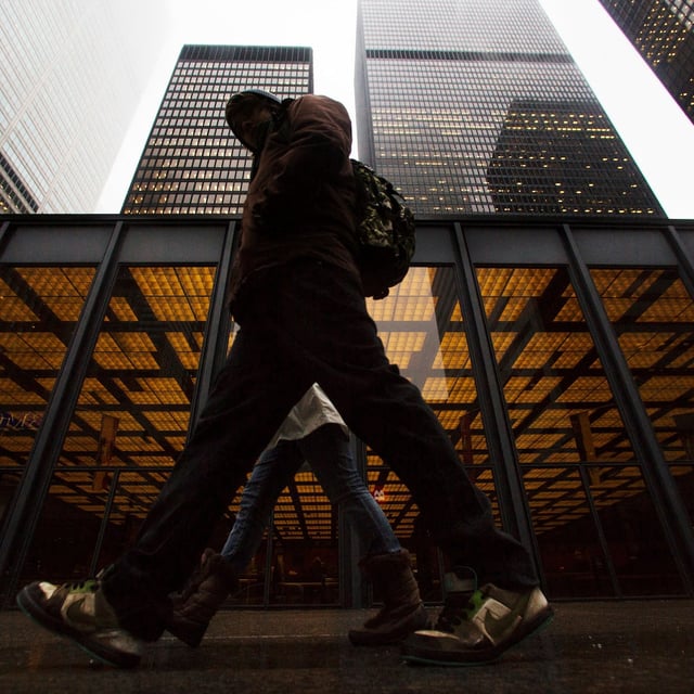 FILE PHOTO: A man walks in front of buildings in the financial district in Toronto, January 28, 2013.     REUTERS/Mark Blinch (CANADA - Tags: BUSINESS POLITICS)/File Photo
