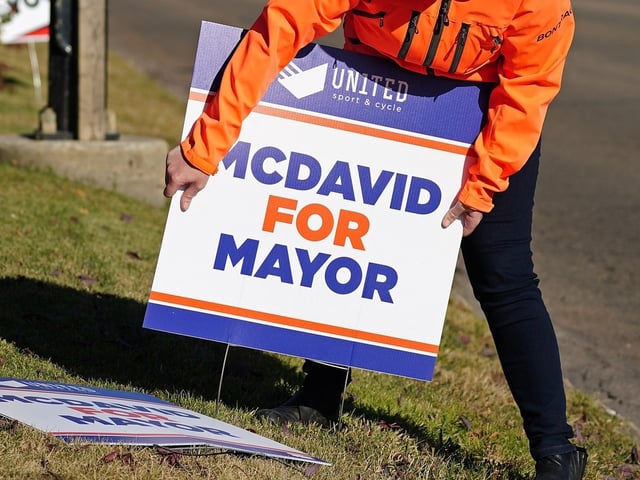 A person puts up a joke election lawn sign in October 2021.