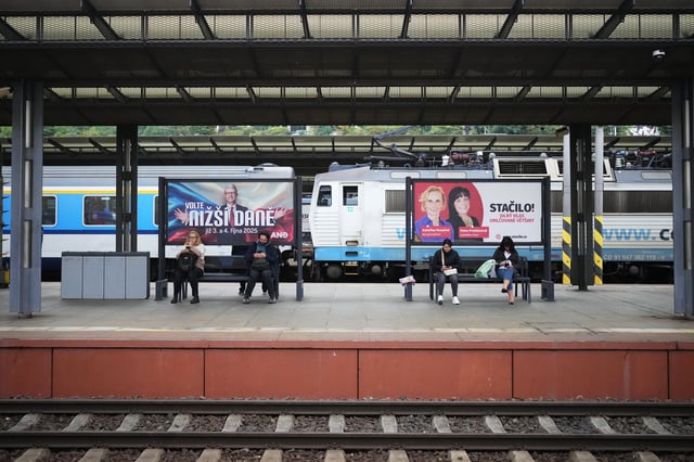 People sit by election posters ahead of Parliamentary elections in Prague, Czech Republic, Sept. 26, 2025. (AP Photo/Petr David Josek)
