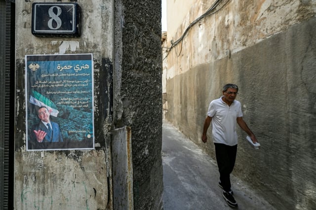 An election poster of Henry Hamra, a Jewish Syrian-American parliamentary candidate, is displayed on the entrance of the closed Jewish Maimonides School of Damascus