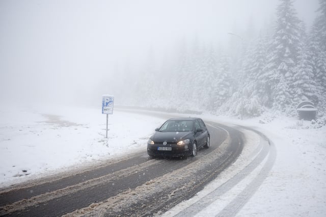 A car drives along a road during an unexpected snowfall on mountain Jahorina near Sarajevo, Bosnia, Thursday, Oct. 2, 2025. (AP Photo/Armin Durgut)