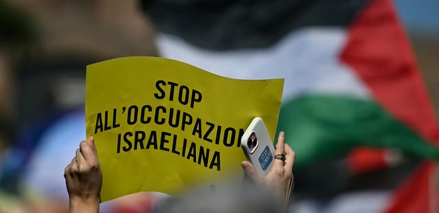Une personne tient une pancarte "Stop à l'occupation israélienne" lors d'une manifestation en solidarité avec les Palestiniens et pour protester contre l'interception de la flottille Global Sumud par l'armée israélienne, à Rome, le 3 octobre 2025